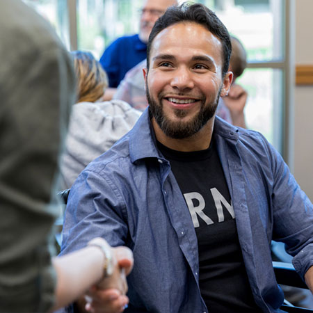 student veteran shakes hands during a meeting